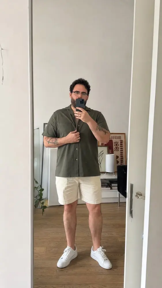 Hombre mostrando un conjunto casual frente al espejo