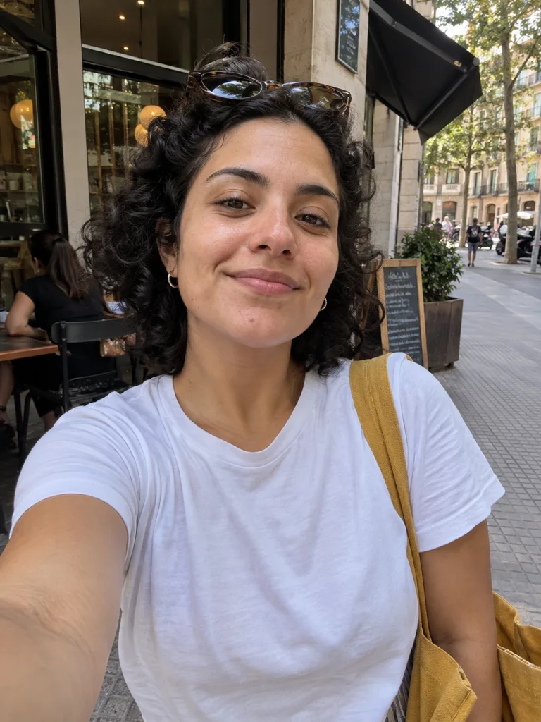 Selfie casual de una mujer con gafas de sol en la cabeza y una bolsa de tela al hombro.